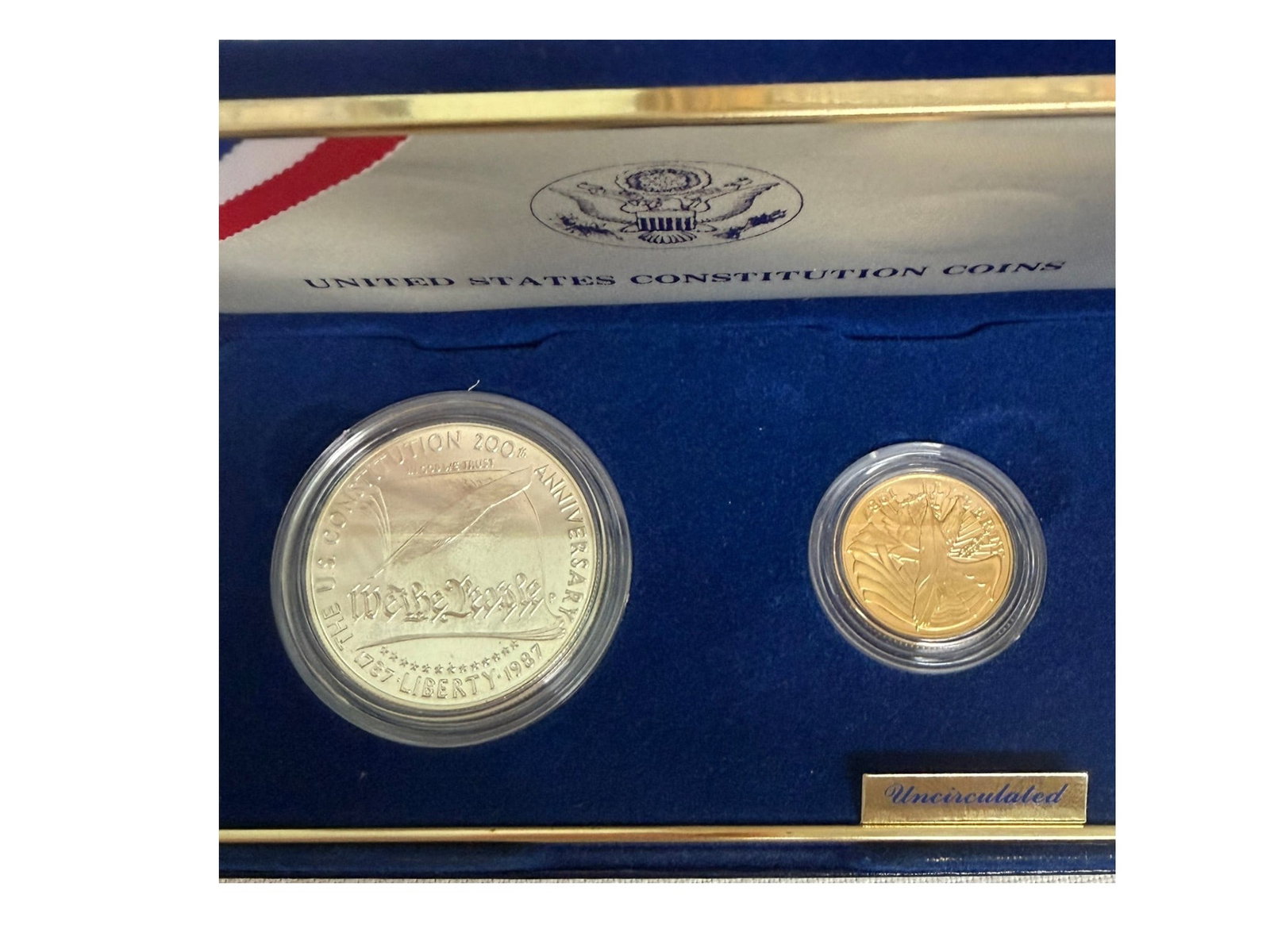 Two U.S. Commemorative Coin Sets – 1986 Statue of Liberty & 1987 Constitution (Silver & Gold): Group of two original U.S. Mint commemorative coin sets, comprising the 1986 Statue of Liberty Centennial set and the 1987 Constitution Bicentennial set, each housed in their original blue velvet pres