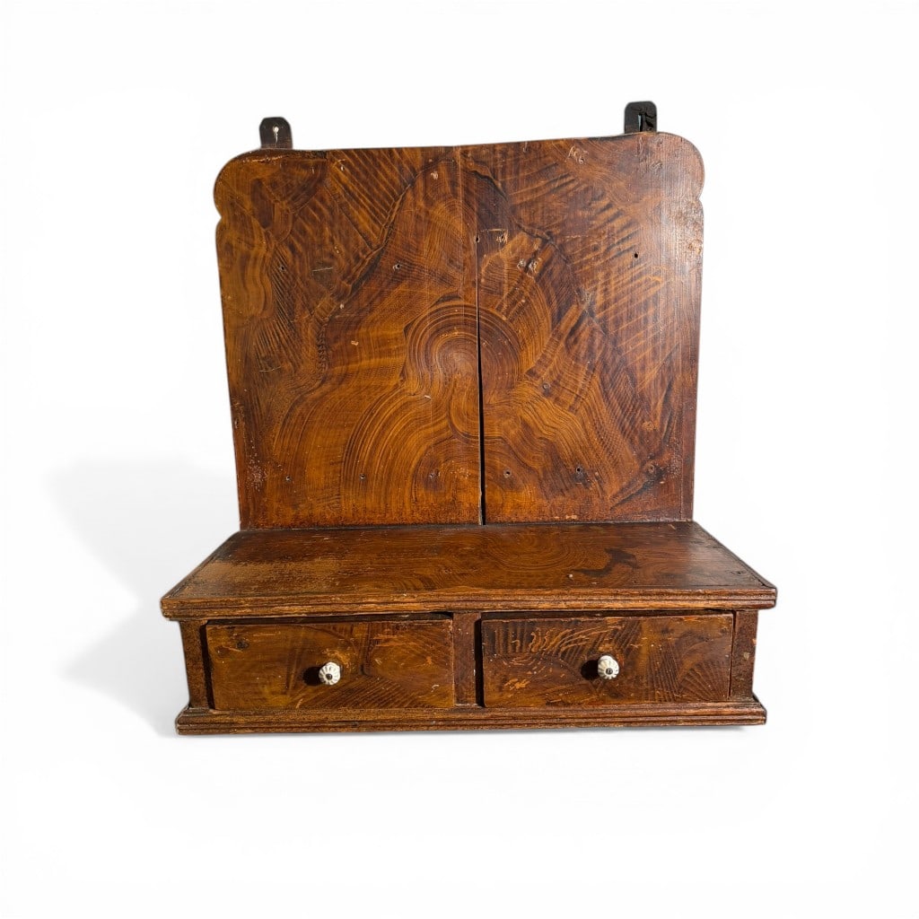 New England Figured Pine Hanging Wall Shelf, Early 19th Century: Early American wall-mounted shelf, likely New England, circa 1820–1840, crafted in pine with exceptional figural grain throughout. The tall backboard displays dramatic cathedral and flame grain patt