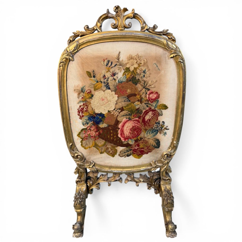 Irish Giltwood Fire Screen with Needlework Panel, Dublin: An elegant Irish giltwood fire screen, 19th century, featuring a finely carved Rococo Revival frame with scrolling crest, foliate ornament, and cabriole-form supports terminating in carved feet. The
