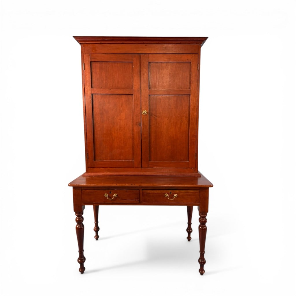 Southern Cherry Step-Back Plantation Desk, 19th Century: Two-piece cherry desk comprising a lower writing table with two drawers raised on turned legs and a removable upper cabinet with molded cornice and paneled double doors opening to fitted interior shel