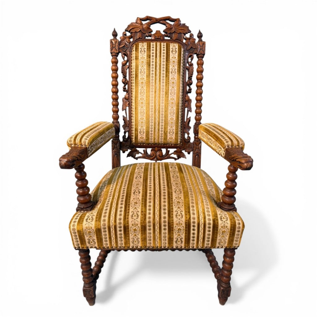 American Renaissance Revival Carved Walnut Armchair with Eagle Terminals: American Renaissance Revival armchair in carved walnut, distinguished by its richly ornamented frame and bold architectural presence. The high rectangular back is framed by turned barley-twist stiles