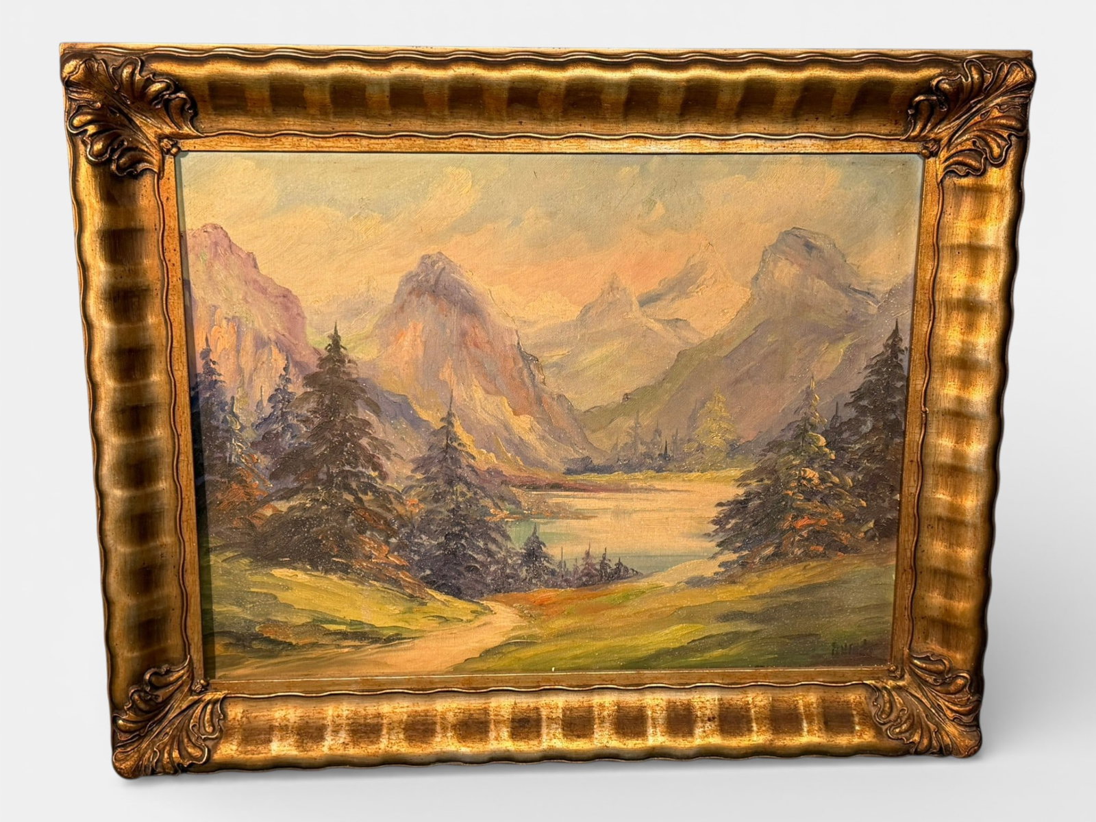 American School Oil on Canvas Mountain Landscape, signed B.H. Duke: Oil on canvas depicting a mountainous landscape with a lake and evergreen trees in the foreground, rendered in a warm tonal palette with visible brushwork. Signed lower right “B.H. Duke.”