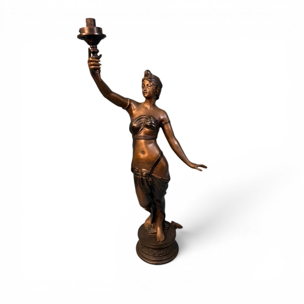 Large Figural Torchère of Classical Maiden, Spelter or Bronze: Large-scale figural torchère depicting a classical maiden in flowing drapery, modeled in a contrapposto stance with one arm raised aloft holding a torch-form candleholder. The figure is rendered