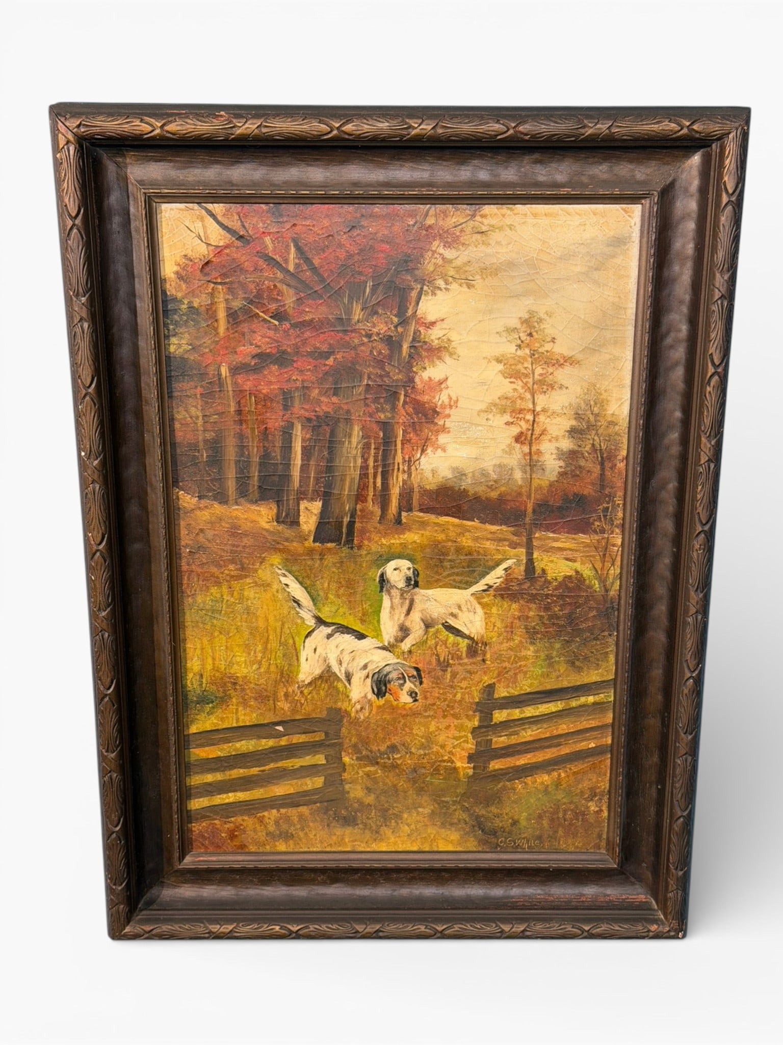 American School Oil on Canvas Hunting Dogs Landscape, signed C.S. White: Oil on canvas depicting two hunting dogs in a wooded autumn landscape with split-rail fence, rendered in warm tones with textured surface and visible craquelure throughout. Signed lower right “C.S.