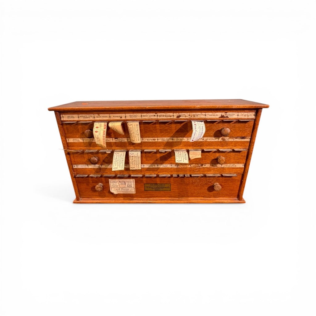 McCloud Label Co. Oak Pharmacy Roll Label Cabinet, Early 20th Century: A scarce and highly appealing American oak pharmacy roll label cabinet manufactured by the McCloud Label Cabinet Co., Bradford, Pennsylvania. This countertop cabinet is fitted with multiple