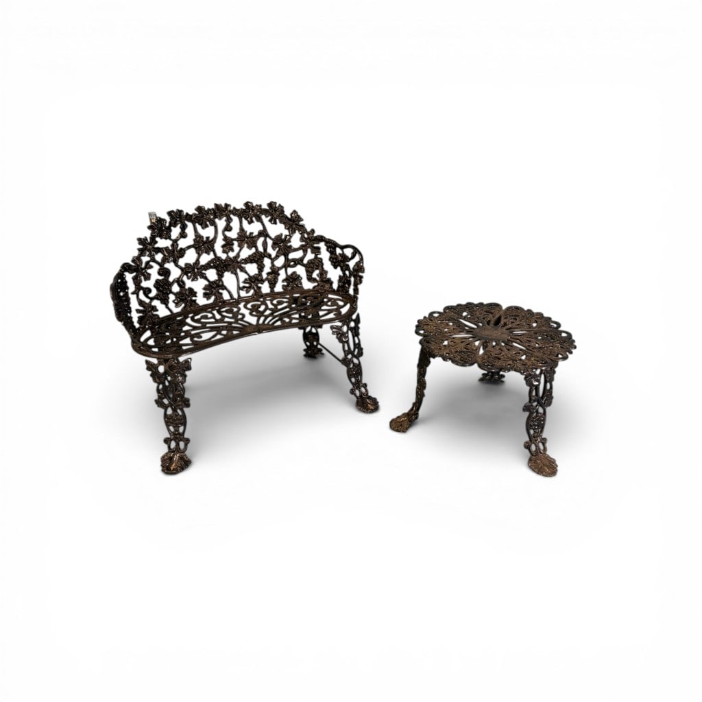 Victorian Cast Iron Garden Bench and Table with Grapevine Motif: Victorian cast iron garden set comprising a curved bench and matching low table, both richly adorned with grapevine and foliate motifs. The bench features an intricately pierced back with intertwined