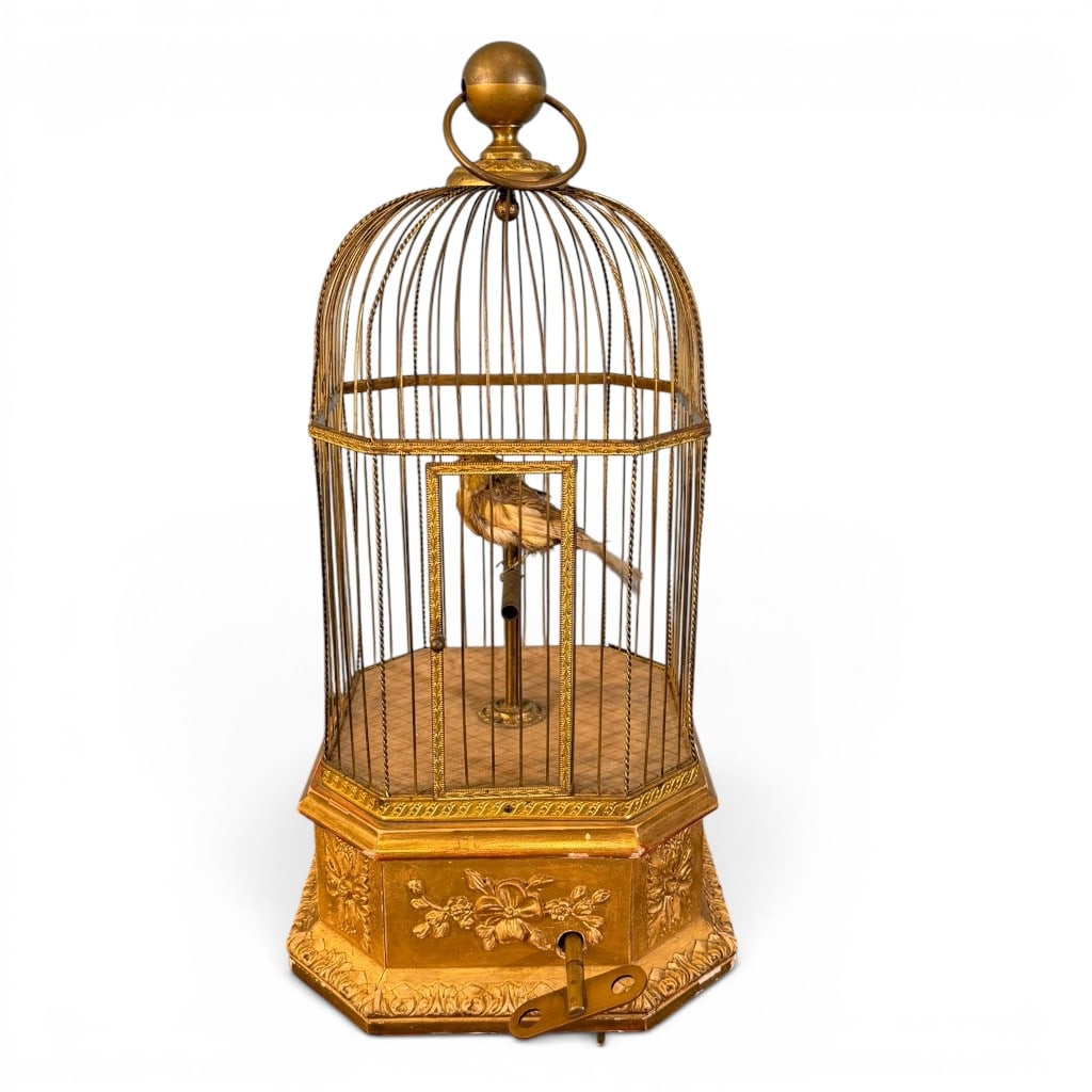 Gilt Metal Singing Bird Automaton Cage, 19th century: Gilt metal mechanical singing bird automaton cage, probably late 19th century, with domed wire cage, floral embossed octagonal base, ring handle finial, hinged front door, winding key, and feathered