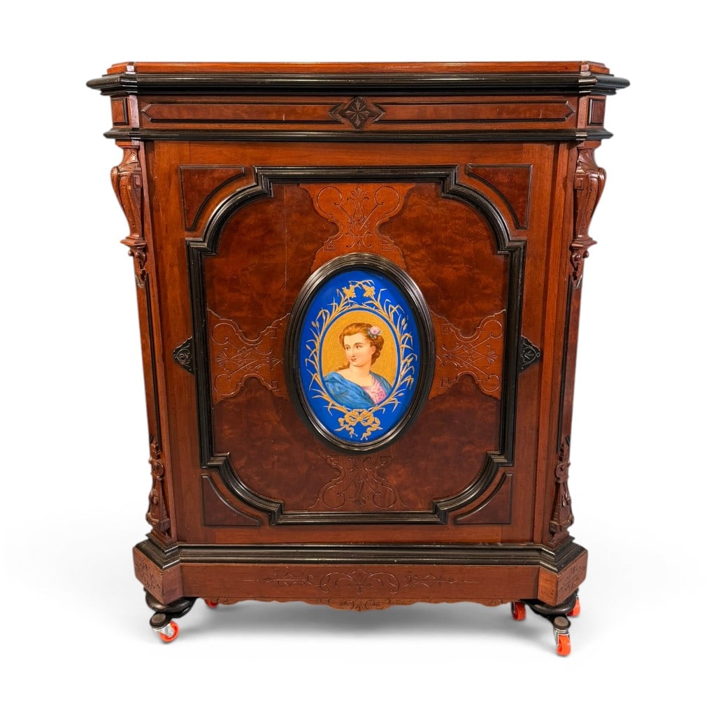 Victorian Burl Walnut and Ebonized Parlor Cabinet with Porcelain Plaque: Victorian burl walnut and ebonized parlor cabinet, late 19th century, having carved Renaissance Revival decoration and rich figured veneer panels. The single large paneled door is centered by an oval