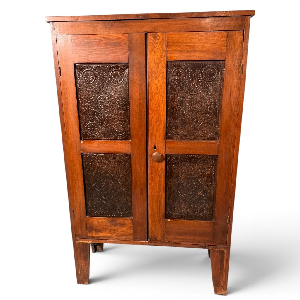American Early Pie Safe with Punched Tin Panels and Red Interior: An American early pie safe, 19th century, of narrow rectangular form with two hinged paneled doors, each fitted with punched tin panels decorated with circular and foliate motifs. The case is