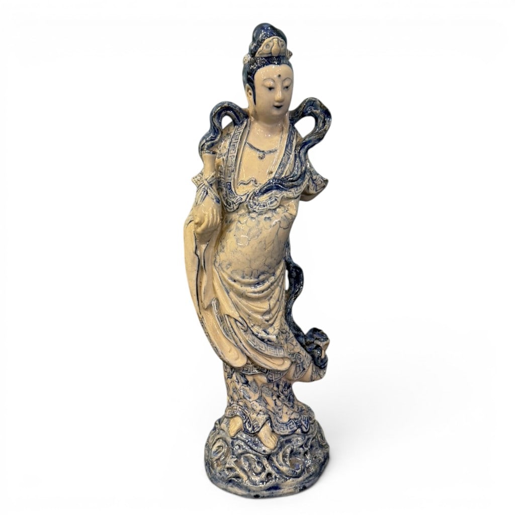 Chinese Blue and White Porcelain Guanyin Figure, Circa 1880: Chinese blue and white porcelain figure of Guanyin, late Qing dynasty, circa 1880, modeled standing in flowing robes on a raised cloud-form base, with blue underglaze decoration highlighting the hair,