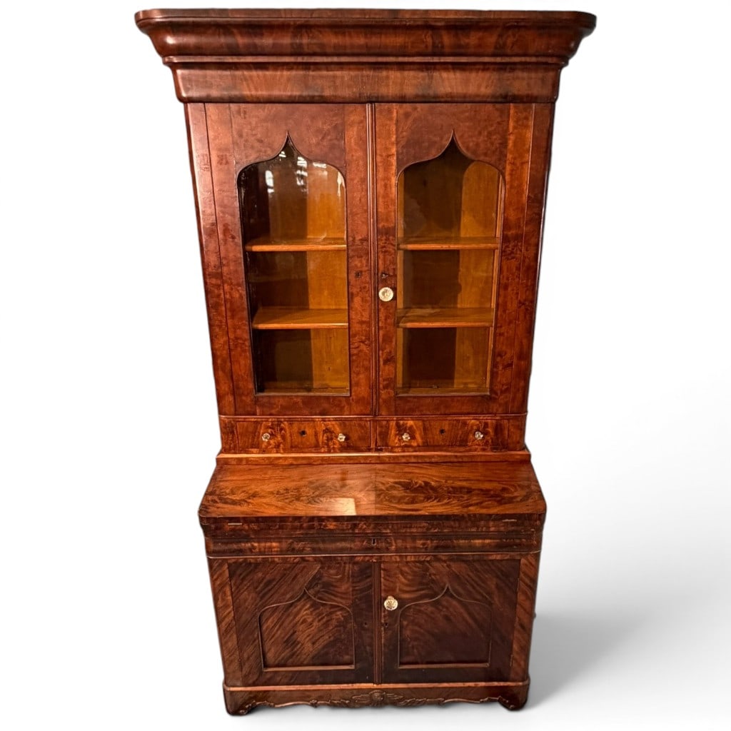 American Gothic Empire Mahogany Secretary Bookcase: An impressive American Gothic Empire secretary bookcase, mid-19th century, in richly figured mahogany and mahogany veneers. The upper case features a bold molded ogee cornice above two glazed cabinet