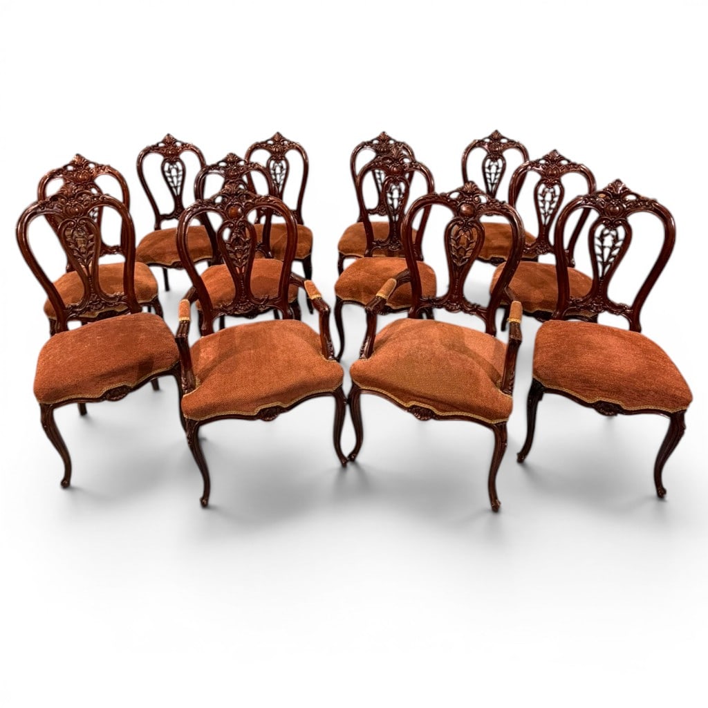 Set of Twelve Carved Victorian Revival Dining Chairs: set of twelve carved Victorian Revival dining chairs, including two armchairs and ten side chairs, each with a richly carved openwork crest and back splat featuring foliate scrolls, shaped reserves,