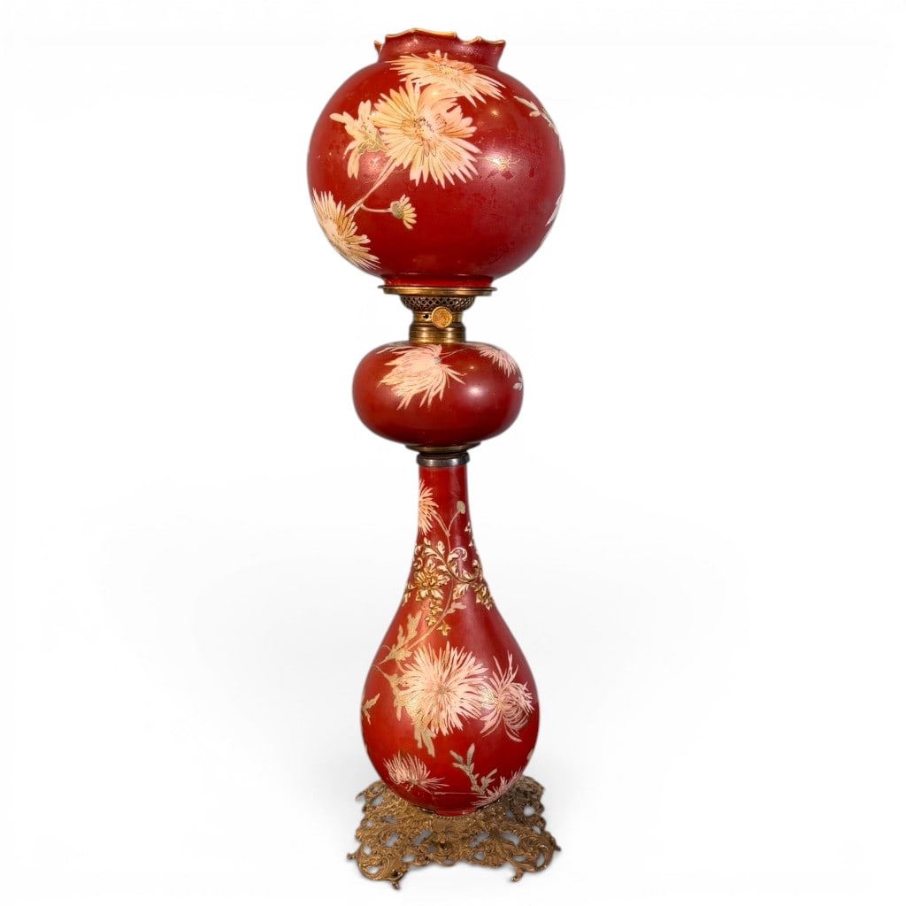 Victorian Ruby Glass Banquet Lamp / Gone with the Wind Lamp: Victorian banquet lamp, commonly called a Gone with the Wind lamp, having matching ruby red glass globe shade, font, and standard with enameled floral decoration, gilt accents, brass burner hardware