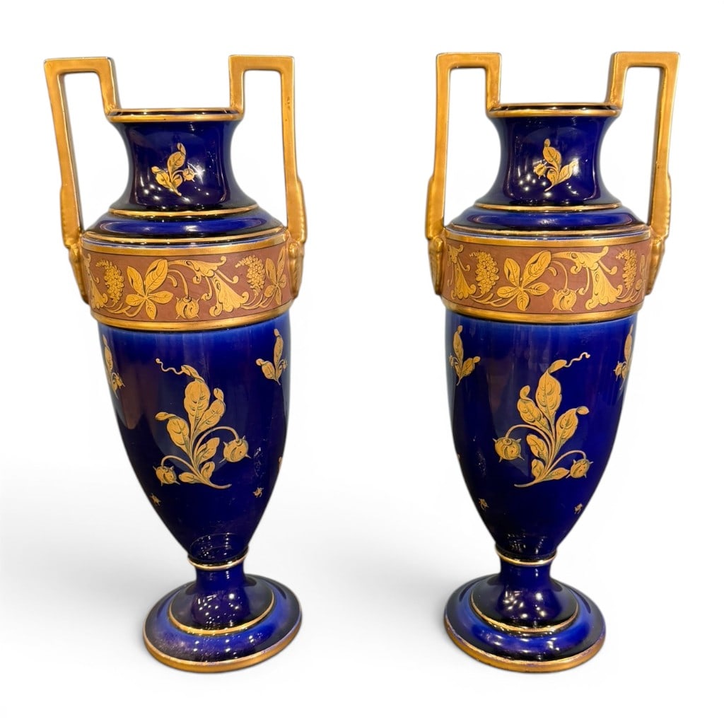 Pair of Cobalt Blue Limoges Porcelain Handled Vases: Pair of French Limoges cobalt blue porcelain vases, marked T&V France, with tall urn-form bodies, squared gilt handles, gilt floral and ribbon decoration, and gilt banding with classical foliate