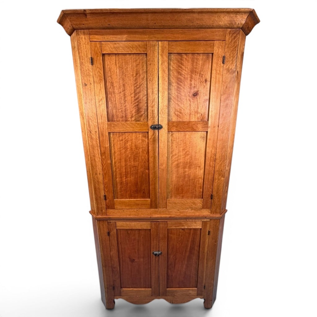 Southern Yellow Pine Corner Cupboard: Southern yellow pine corner cupboard, 19th century, of tall two-part country form with a bold projecting molded cornice above an upper case fitted with two paneled cupboard doors opening to shaped