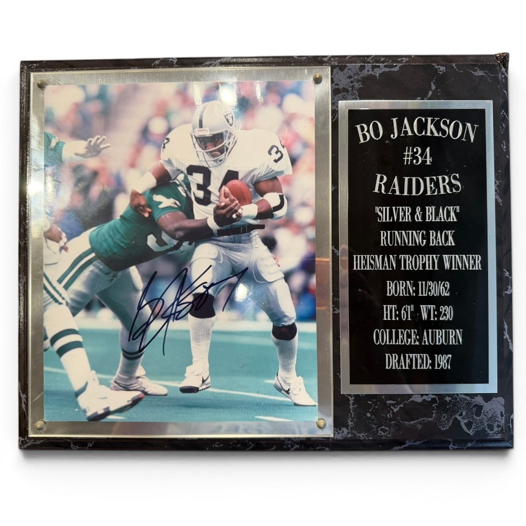 Signed Bo Jackson Oakland Raiders Photograph Plaque: Signed color photograph of Bo Jackson as running back for the Oakland Raiders, mounted with engraved plaque noting ?Bo Jackson #34 Raiders,? ?Silver & Black,? Heisman Trophy winner, Auburn, and