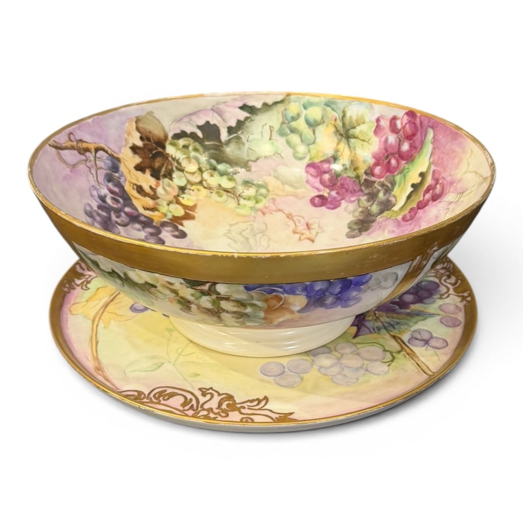 La Roche Limoges Hand-Painted Grape Bowl and Underplate: La Roche Limoges porcelain bowl and matching underplate, hand-painted with grape clusters, vine leaves, and soft pastel ground, with gilt rim and gilt banding. The bowl is decorated both to the
