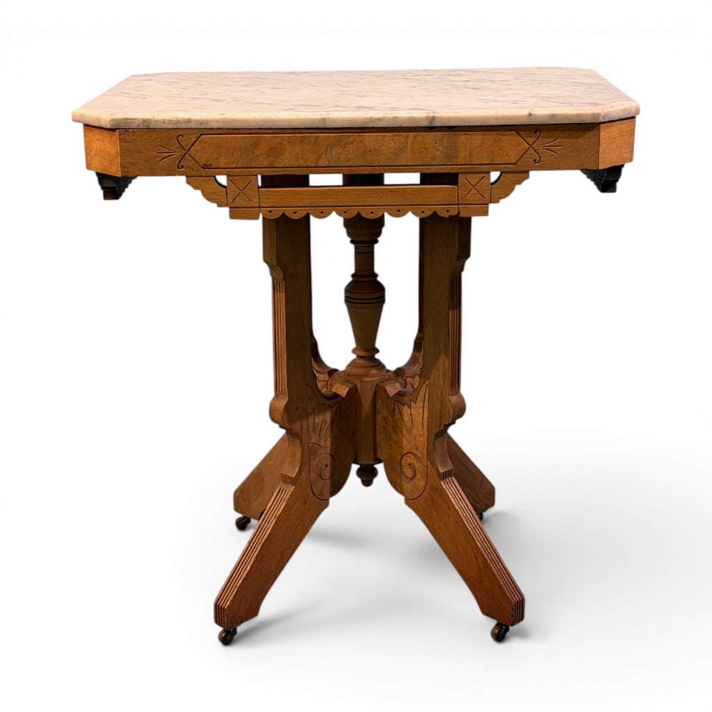 Eastlake Marble-Top Side Table, Late 19th Century: Eastlake side table, late 19th century, having a shaped white marble top with canted front corners over a light-finished walnut or mixed hardwood base. The frieze is decorated with incised Eastlake li