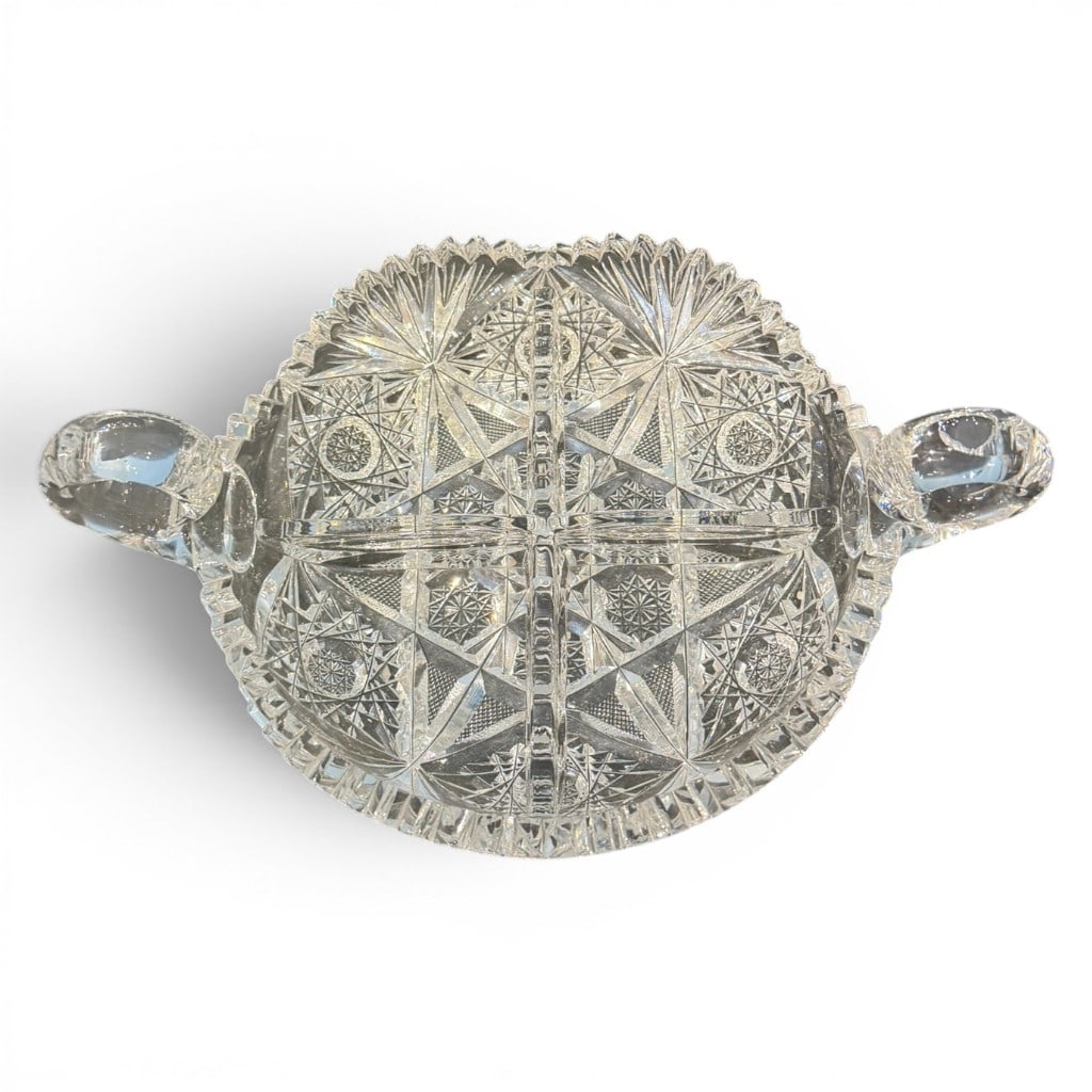 American Brilliant Period Cut Glass Two-Handled Candy or Nut Dish: American Brilliant Period cut glass candy or nut dish, circular shallow bowl form with opposing applied loop handles, scalloped and notched rim, and deep cutting throughout in hobstar, fan, crosshatch