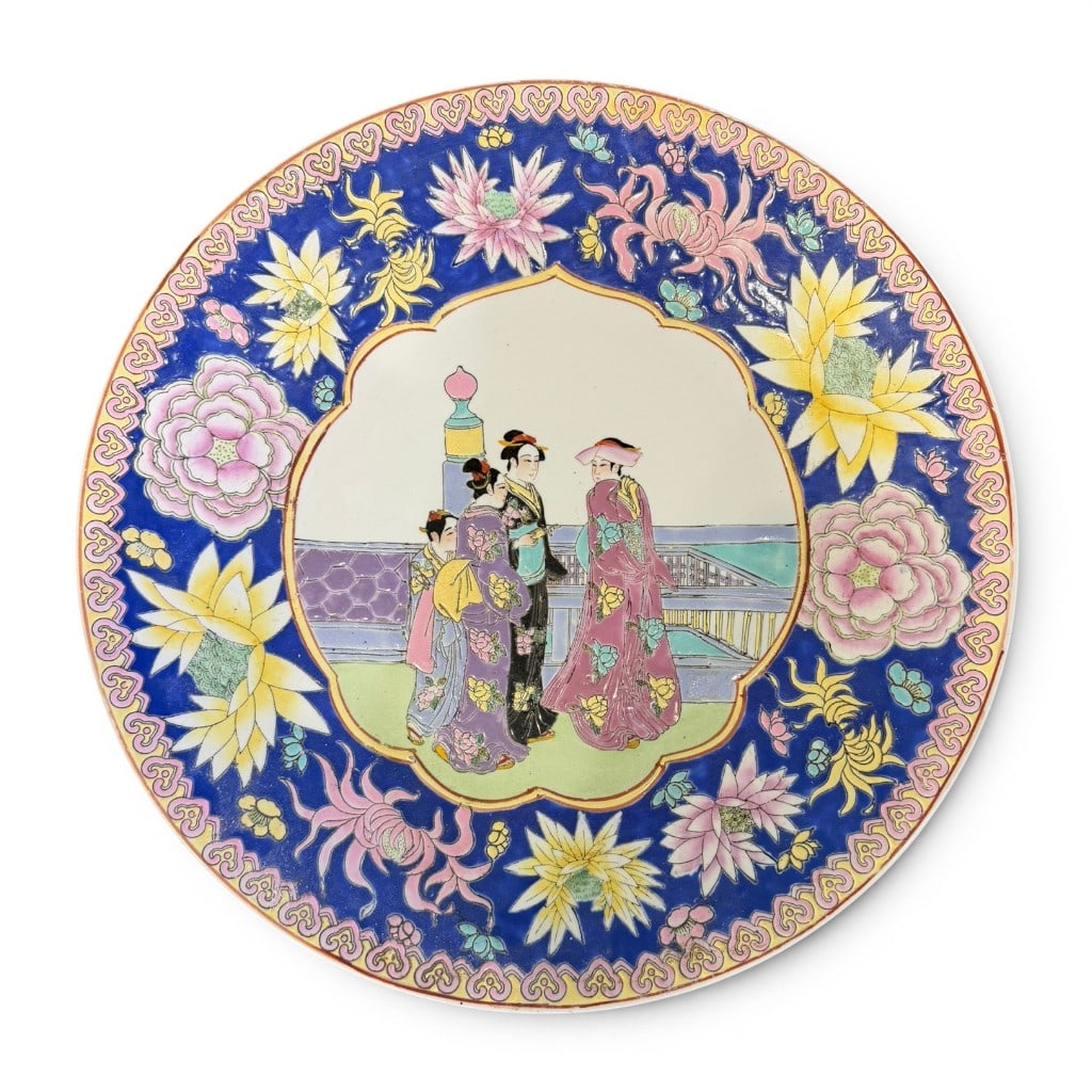 Large Chinese Famille Rose Porcelain Charger with Court Figures: Large Chinese famille rose porcelain charger or shallow plate, 20th century, decorated with a central shaped reserve depicting courtly figures on a terrace, enclosed by a vibrant cobalt-blue border wi