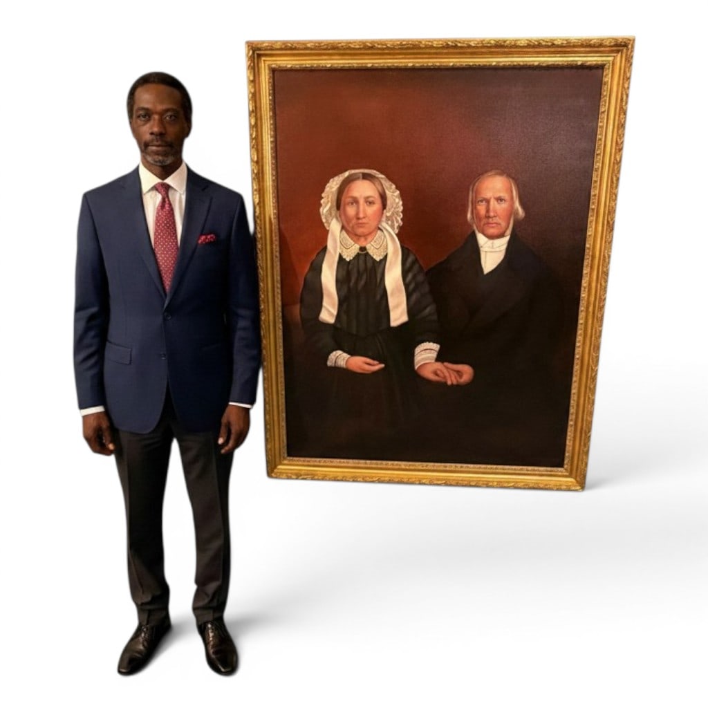 Large American Folk Art Double Portrait of Husband and Wife: A large American folk art oil on canvas double portrait of a husband and wife, late 20th century, painted in the style of mid-19th century American ancestral portraiture. The sitters are shown seated
