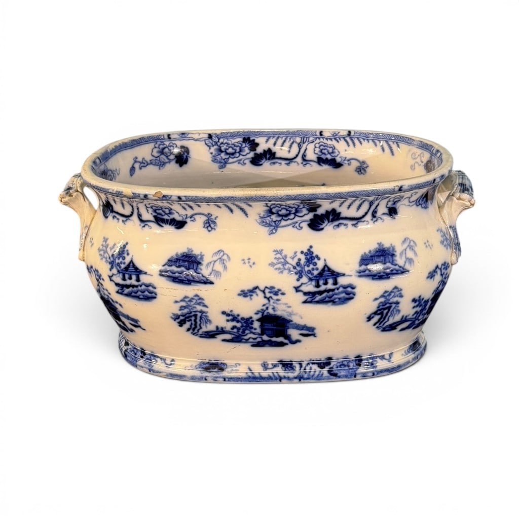 Hong Kong Blue and White Porcelain Planter / Jardiniere: A blue and white porcelain jardiniere or plant tub, marked Hong Kong to underside, mid-20th century, of oval bombe form with molded handles and footed base, decorated throughout in underglaze blue