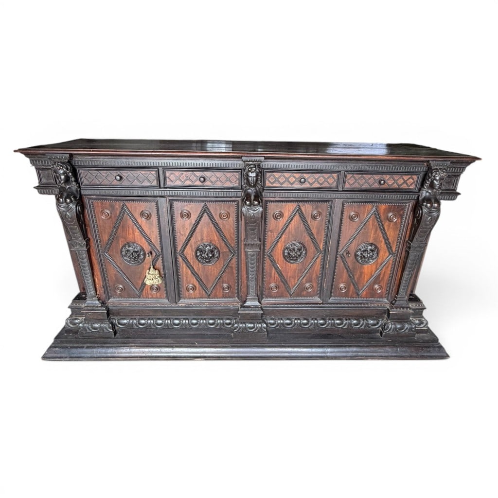 Monumental Renaissance Revival Carved Sideboard: Monumental Renaissance Revival carved walnut and ebonized sideboard, late 19th century, of impressive architectural form with long rectangular top above a case fitted with upper drawers and four cabin