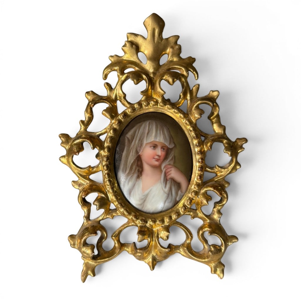 Hand Painted Porcelain Portrait Plaque in Gilt Frame: Hand painted porcelain portrait plaque in ornate gilt metal or composition frame, late 19th to early 20th century, depicting a young woman in white veil or head covering. The reverse appears inscribed