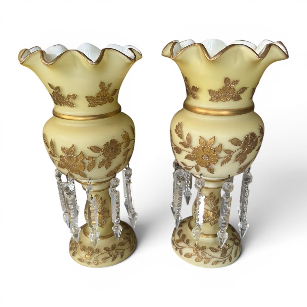 Pair of Victorian Custard Glass Lustres: Pair of Victorian custard glass lustres, late 19th century, each with ruffled rim, white interior, gilt floral decoration, gilt banding, and hanging cut glass prism drops. A decorative pair with pleas