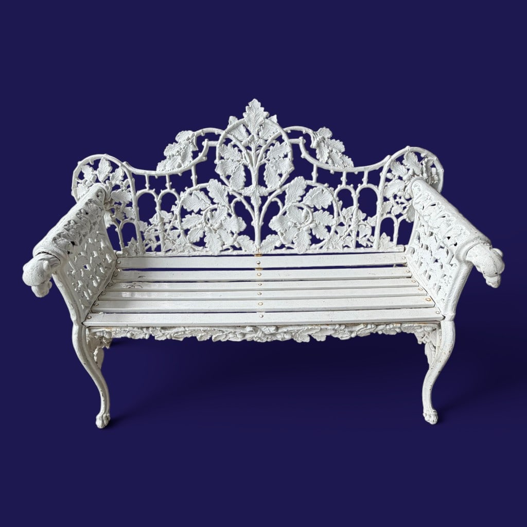 Cast Iron and Wood Garden Bench with Dog Head Arms: Cast iron and wood garden bench, in the Victorian style, having cast iron sides with dog head arm terminals and scroll supports, fitted with later or replaced wooden slats. 38 in. H, 52 in. W, 15 in. 