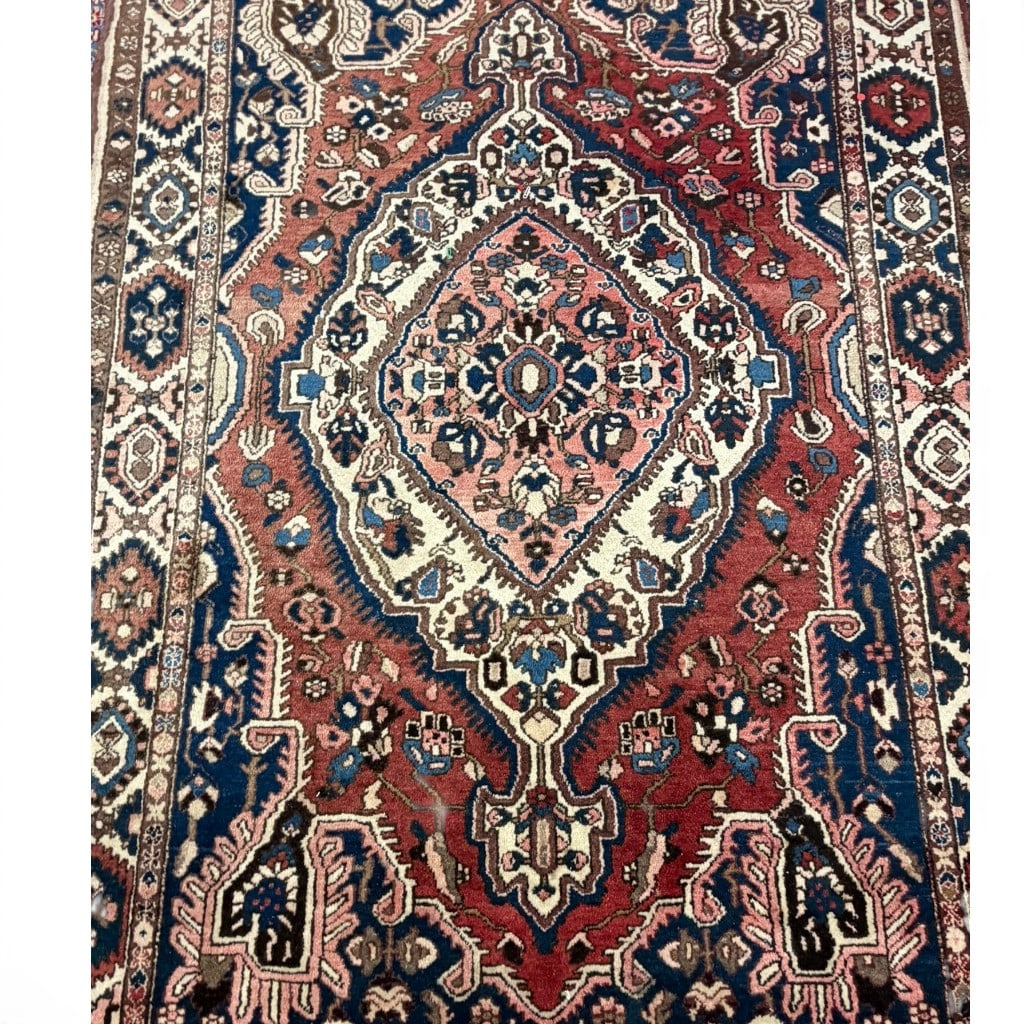 Hand knotted Heriz medallion carpet, having a red field centered by a large stepped geometric (1 of 2)