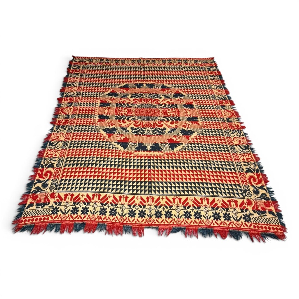 19th Century Red, White, and Blue Woven Coverlet: 19th century red, white, and blue woven coverlet or blanket, having bold geometric field with repeating triangular devices, central medallion, foliate border, and red and blue fringe. Strong