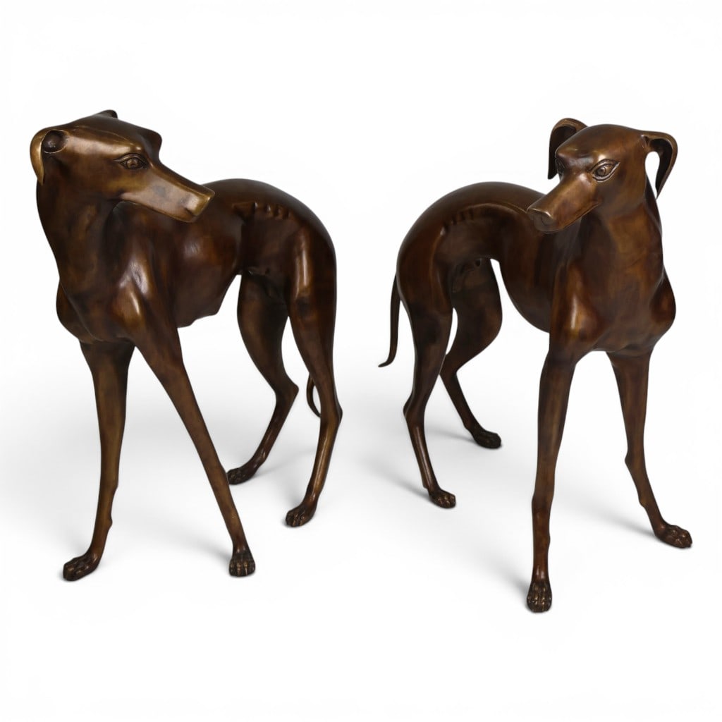 Pair Life-Size Bronze Greyhound Figures: Date: Early 20th centuryPeriod/Style: Naturalistic with Art Deco influenceMaterials: Heavy cast bronze with brown patinaForm: Pair of life-size standing greyhound or whippet sculpturesDescription: A s