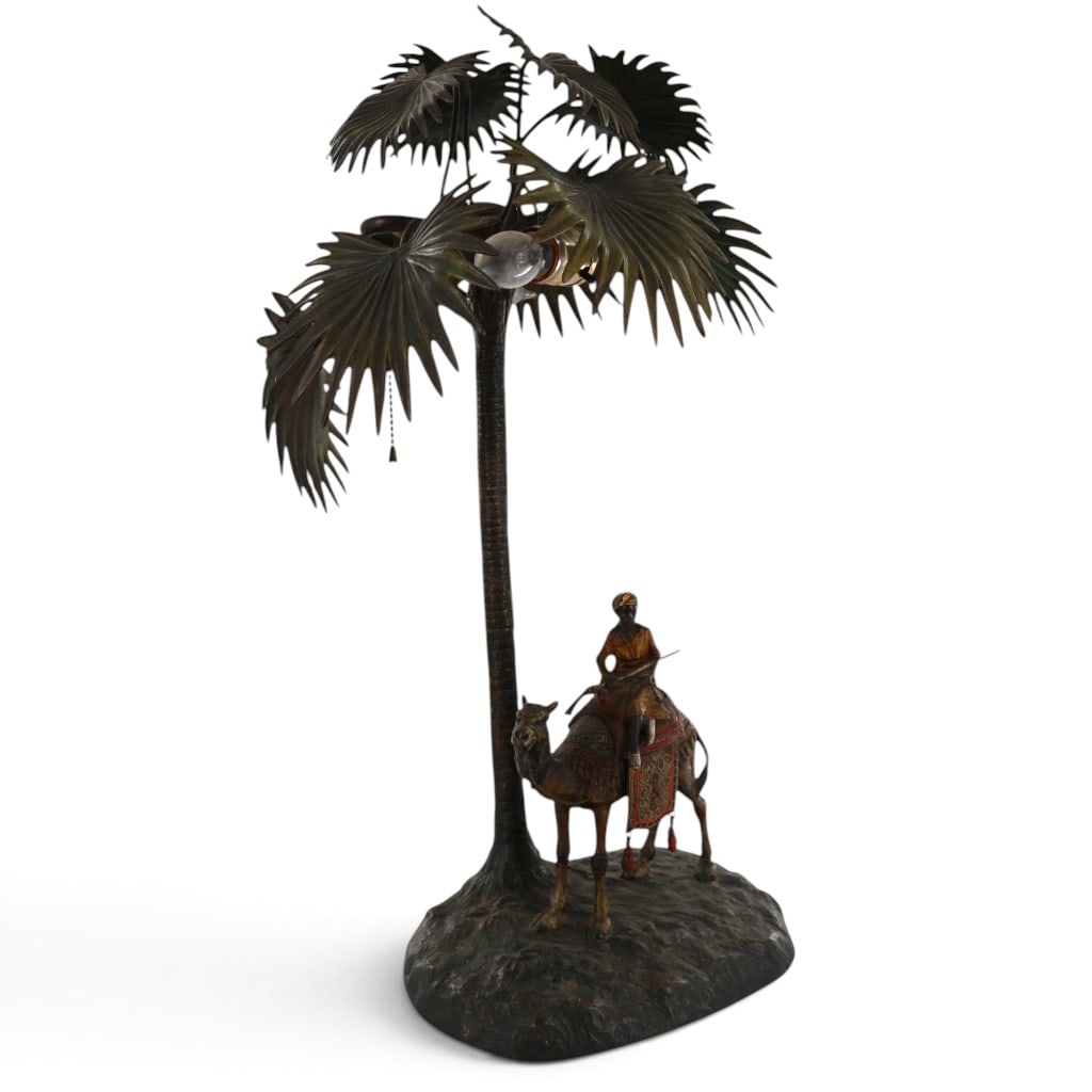 Austrian Camel and Palm Tree Lamp: Origin: Austria, probably ViennaDate: Early 20th century, circa 1900-1920Period/Style: Austrian OrientalistMaterials: Cold-painted cast metal, sheet metal, and electrical fittingsForm: Figural