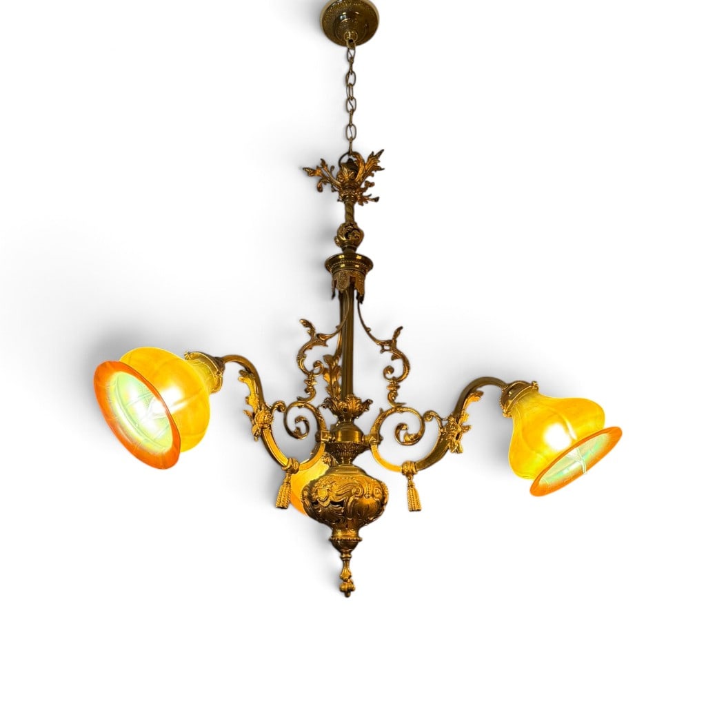 Rococo Chandelier with R.G.F. Shades: Maker: Shades marked R.G.F.Origin: American, probablyDate: Circa 1910-1925Period/Style: Rococo Revival and Beaux-ArtsMaterials: Gilt cast metal, brass, and iridescent blown art glassDescription: An