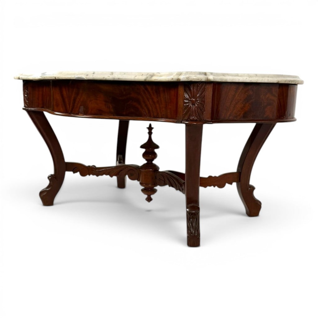 Victorian Marble-Top Coffee Table: Origin: American Date: Circa 1850-1870, later altered Period/Style: American Rococo Revival Materials: Mahogany, figured mahogany veneer, white marble, and mixed secondary woods Form: Center table