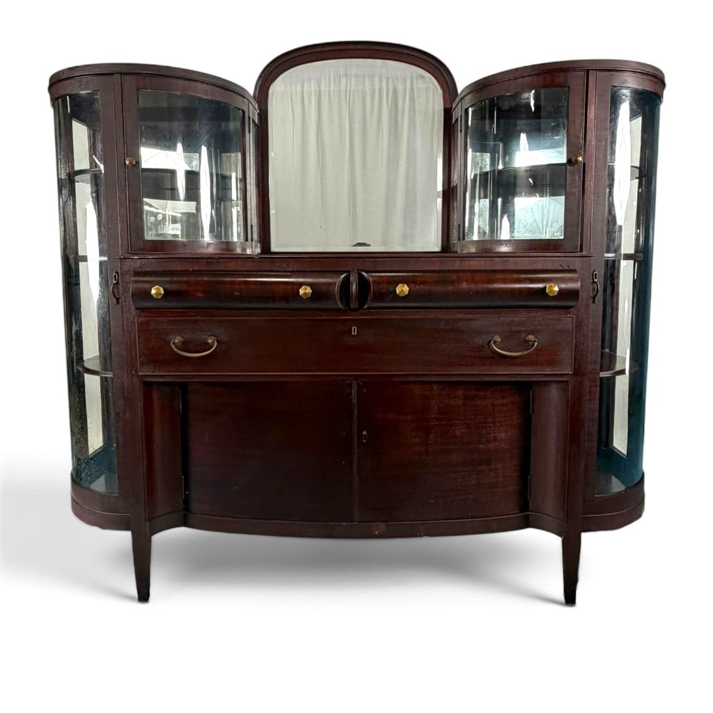 American Mahogany Curved-Glass Combination Sideboard and China Cabinet: Origin: Probably American Date: Circa 1900 Period/Style: Late Victorian Materials: Mahogany, mahogany veneer, curved glass, mirror glass, green felt, and brass hardware Description: A distinctive