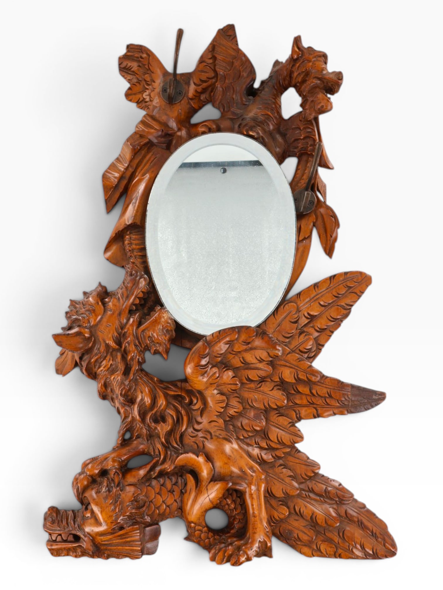 Carved Dragon Mirror and Coat Rack: Origin: Continental Europe Date: Late 19th to early 20th century, with possible later alterations Period/Style: Black Forest style / Gothic Revival Materials: Carved wood, beveled mirror glass, and me
