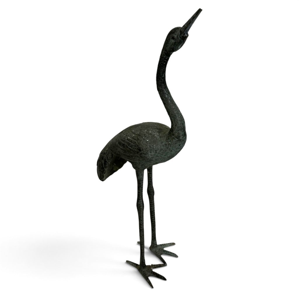 Large Patinated Cast Bronze Crane Garden Sculpture: Origin: Probably Asian manufacture for the Western decorative market Date: 20th century Materials: Cast bronze Form: Garden sculpture Description: A large cast bronze garden sculpture modeled as a