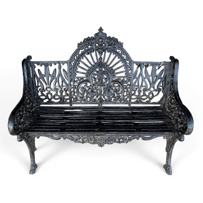 Ornate Black Cast Iron Garden Bench: Date: Early 20th century Period/Style: Victorian Revival, Gothic and Rococo Revival influence Materials: Cast iron and black-painted finish Form: Two-seat garden bench Description: An ornate cast iron