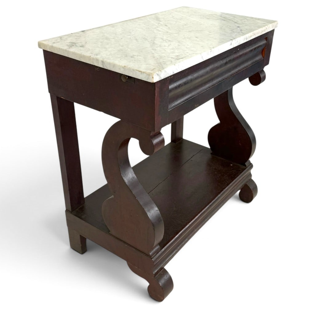 American Empire Mahogany Marble-Top Washstand: Origin: American Date: Circa 1840-1860 Period/Style: Late Classical, Empire Materials: Mahogany, mixed secondary woods, white marble, and metal hardware Form: Marble-top washstand Description: An