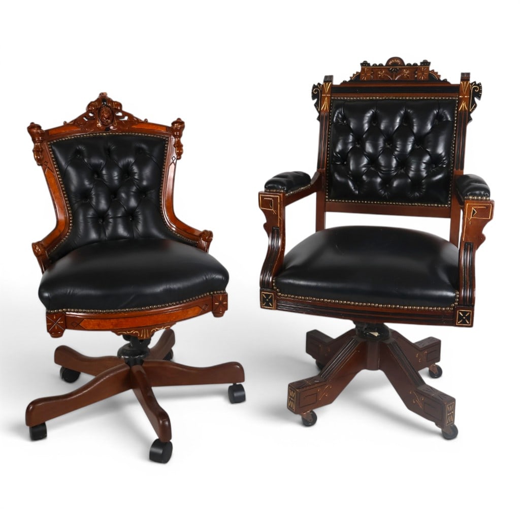 Two Victorian Revival Swivel Chairs: Date: Late 20th century Period/Style: Victorian Revival Materials: Carved and ebonized hardwood, gilt decoration, black tufted leather upholstery, metal hardware, and casters Form: Associated swivel