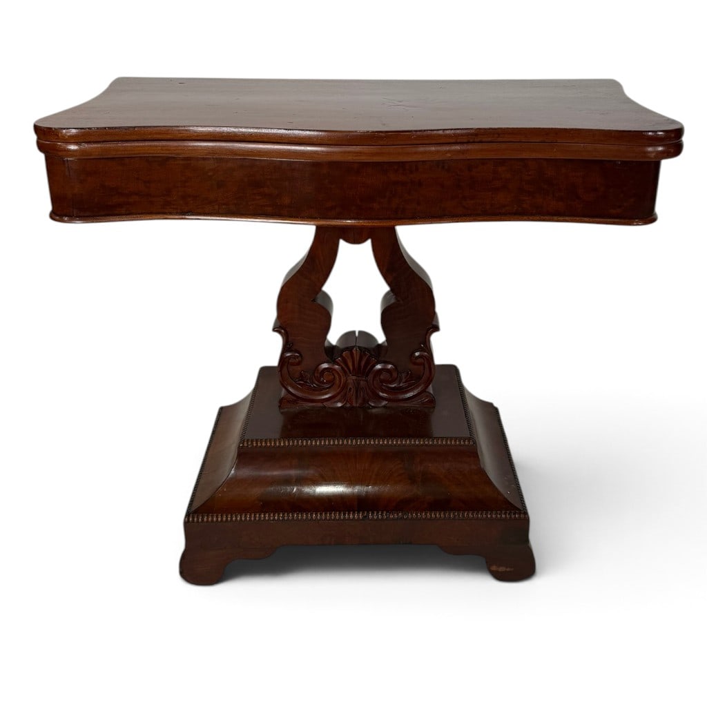 American Classical Mahogany Lyre-Base Flip-Top Card Table, Circa 1825-1840: Origin: American Date: Circa 1825-1840 Period/Style: American Classical Materials: Mahogany, mahogany veneer, and mixed secondary woods Description: An American Classical mahogany card table with a