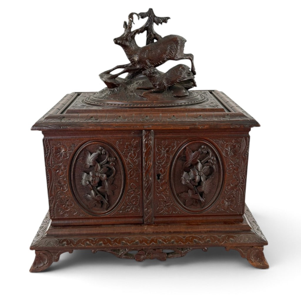 Swiss Black Forest Carved Deer Cigar Cabinet: Origin: Probably Brienz, Switzerland Date: Circa 1880-1900 Period/Style: Black Forest, late Victorian Materials: Carved and stained wood with brass hardware Form: Two-door table cigar cabinet or