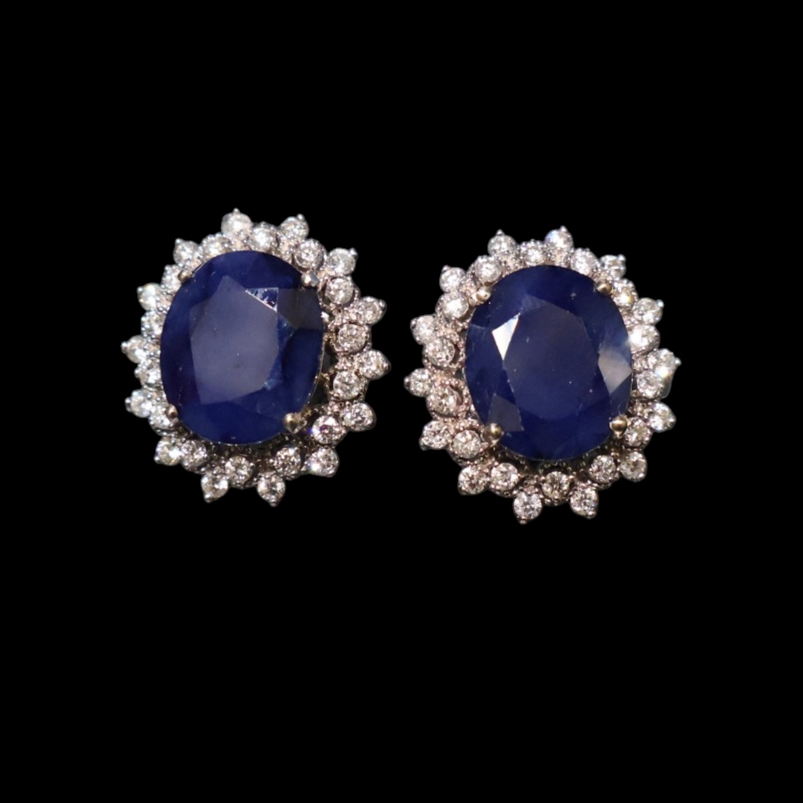 14K Sapphire and Diamond Earrings: Date: Late 20th to early 21st century Materials: 14K white gold, sapphires, and diamonds Form: Pair of earrings Description: A pair of 14K white gold cluster earrings, each centering an oval blue