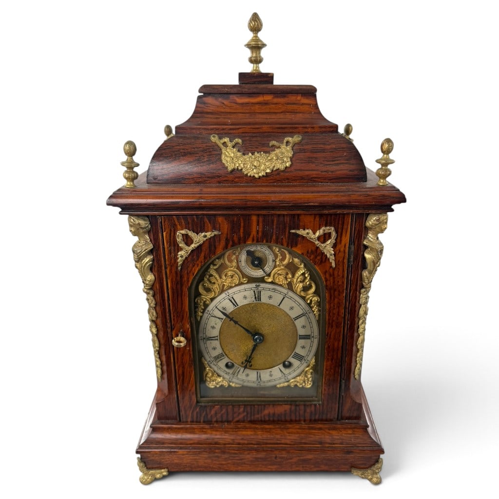 German Rosewood and Gilt Bronze Clock: Origin: Germany Date: Circa 1890-1900 Period/Style: Historicism and Baroque Revival Maker: Unidentified Materials: Rosewood veneer, gilt bronze, brass, glass, steel, and fabric Form: Bracket-form