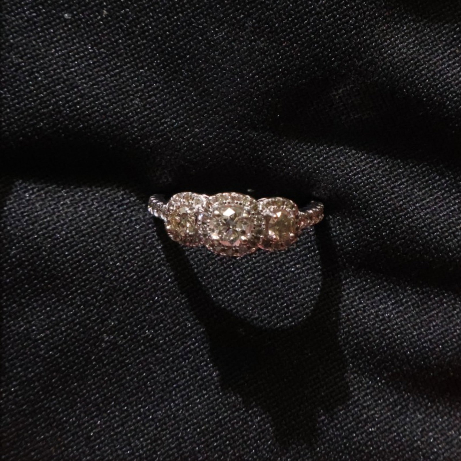 10K White Gold Three-Stone Diamond Ring: Date: Late 20th to early 21st century Materials: 10K white gold and diamonds Form: Three-stone ring Description: A 10K white gold ring set with three principal diamonds in a linear raised setting, wit