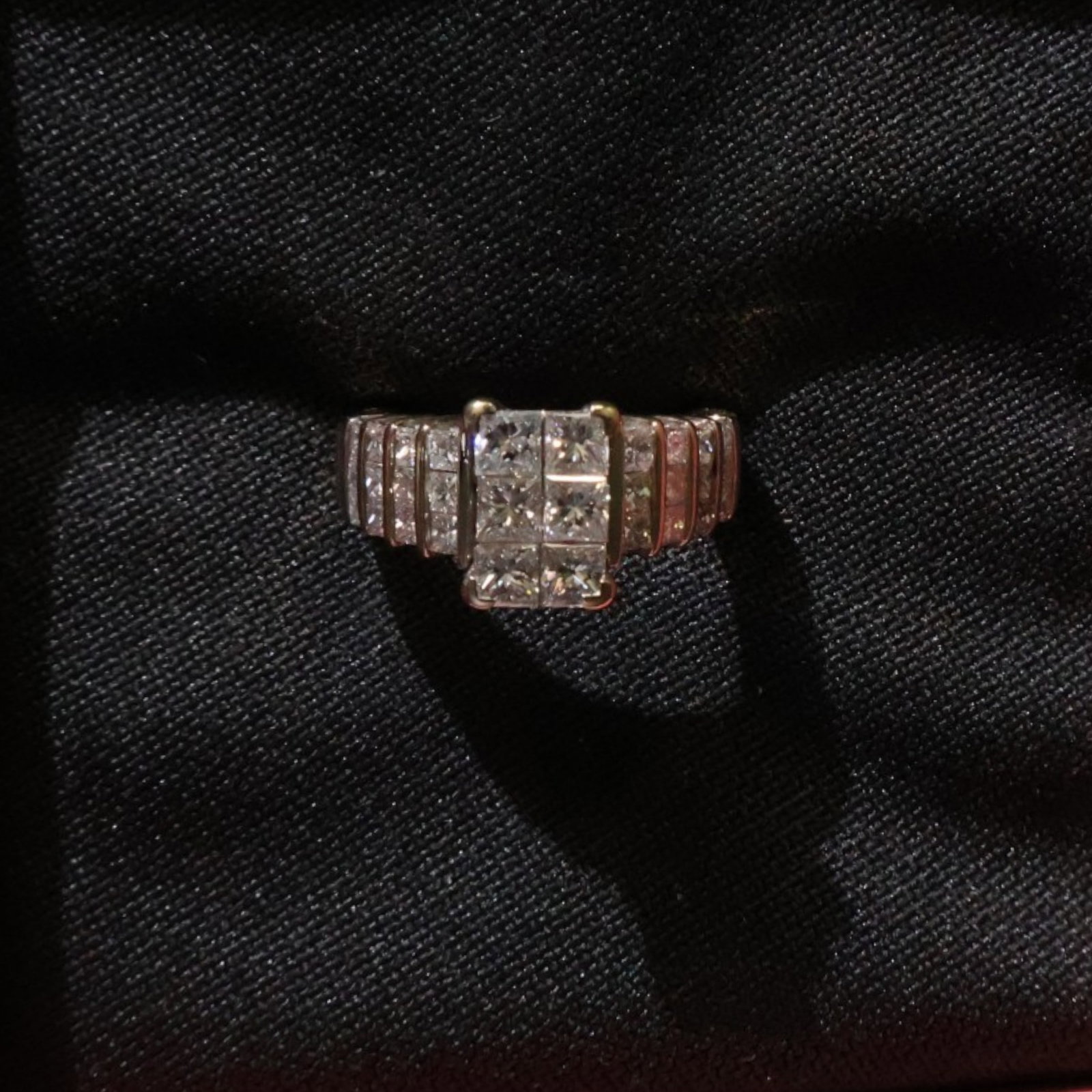 14K Yellow Gold Diamond Ring: Date: Late 20th to early 21st century Materials: 14K yellow gold and diamonds Form: Ring Description: A 14K yellow gold diamond ring with a raised center setting and diamond accents extending across