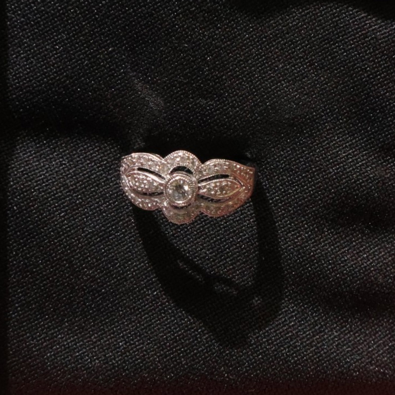 18K White Gold Diamond Ring: Date: Late 20th to early 21st century Materials: 18K white gold and diamonds Form: Ring Description: An 18K white gold diamond ring with a central diamond cluster and additional stones set along the