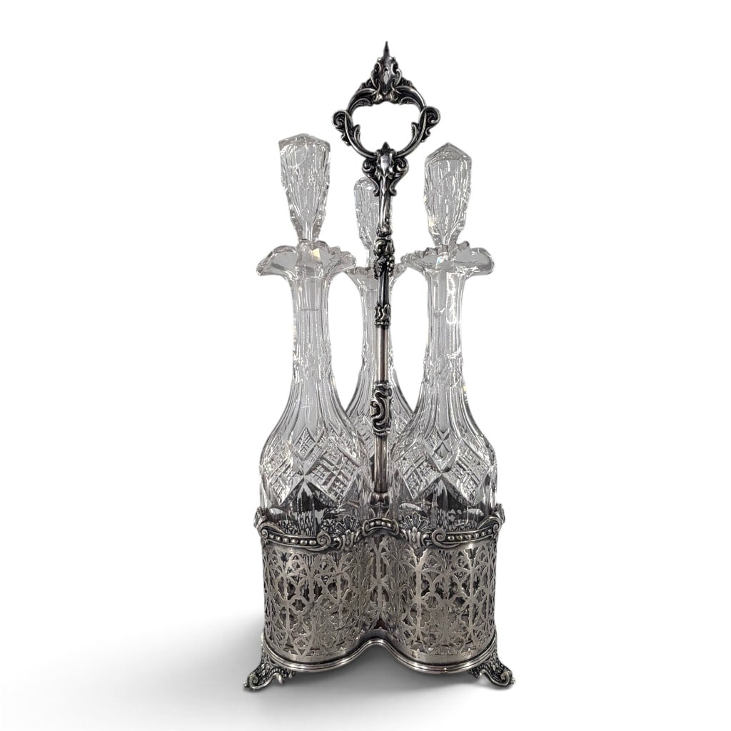 Victorian Triple Decanter Silverplate Set: Origin: Probably England Date: Late 19th to early 20th century Period/Style: Victorian and Rococo Revival Maker: Unmarked Materials: Silverplate and cut glass Form: Three-bottle decanter set in